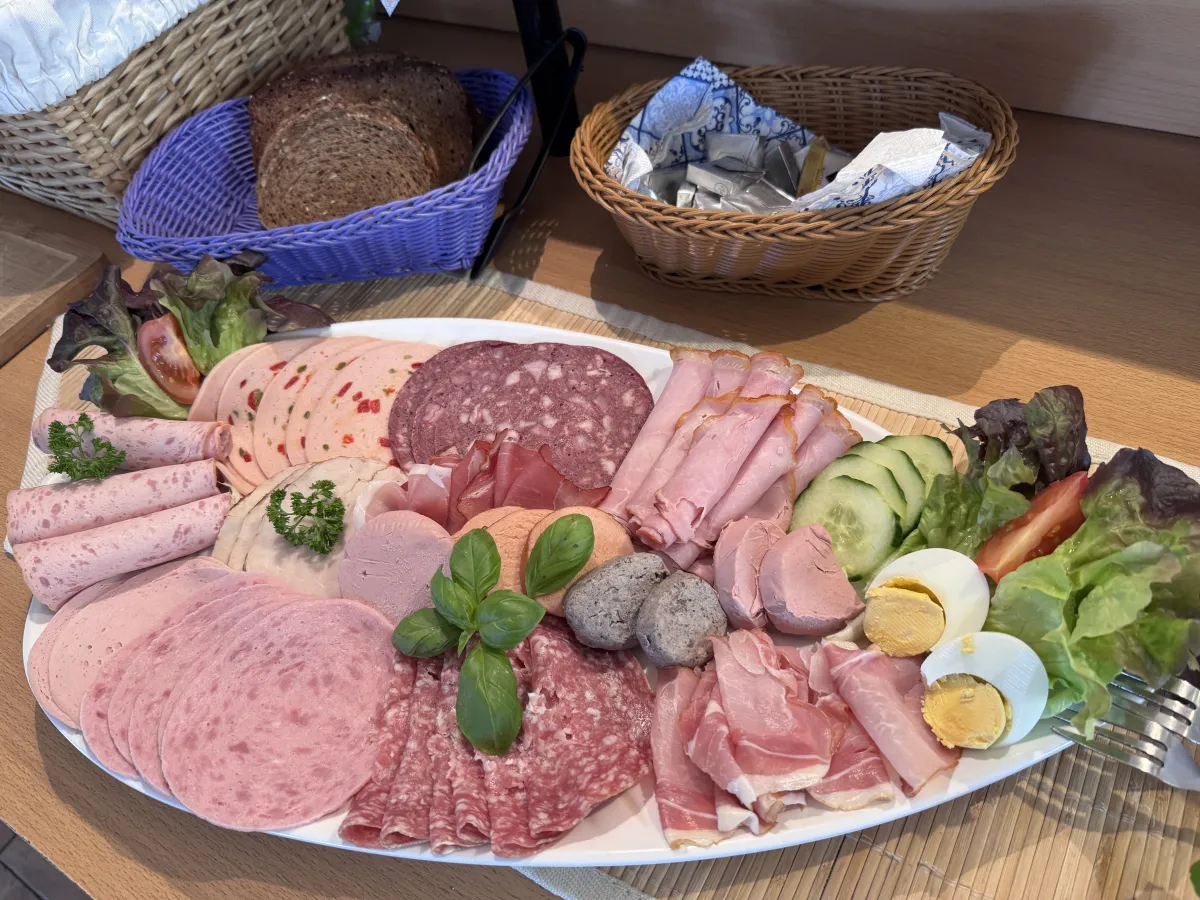 Wurstplatte mit Brot und Ei am Frühstücksbuffet