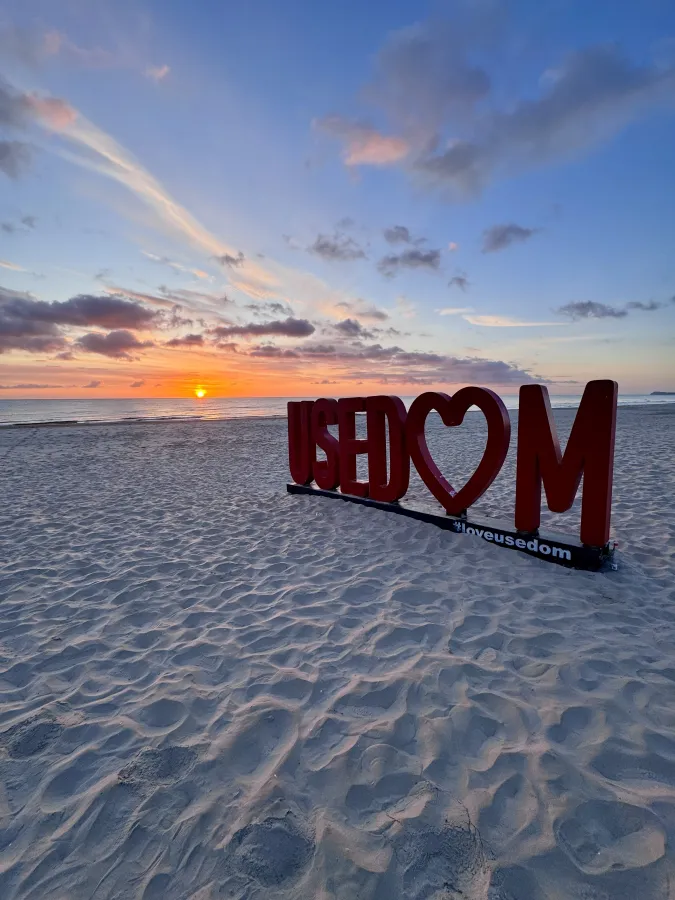 USEDOM-Schriftzug am Strand bei Sonnenuntergang