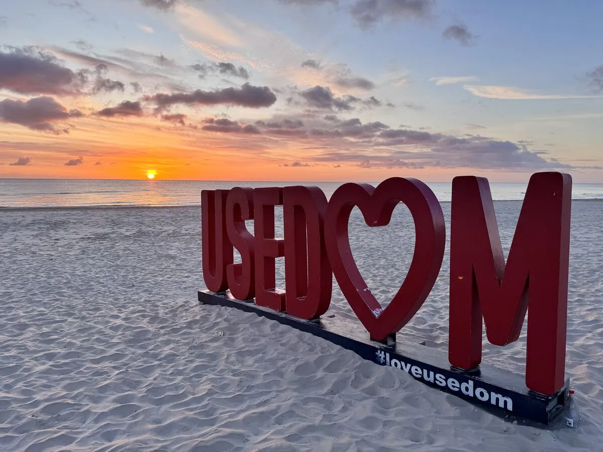 USEDOM-Schriftzug am Strand bei Sonnenuntergang